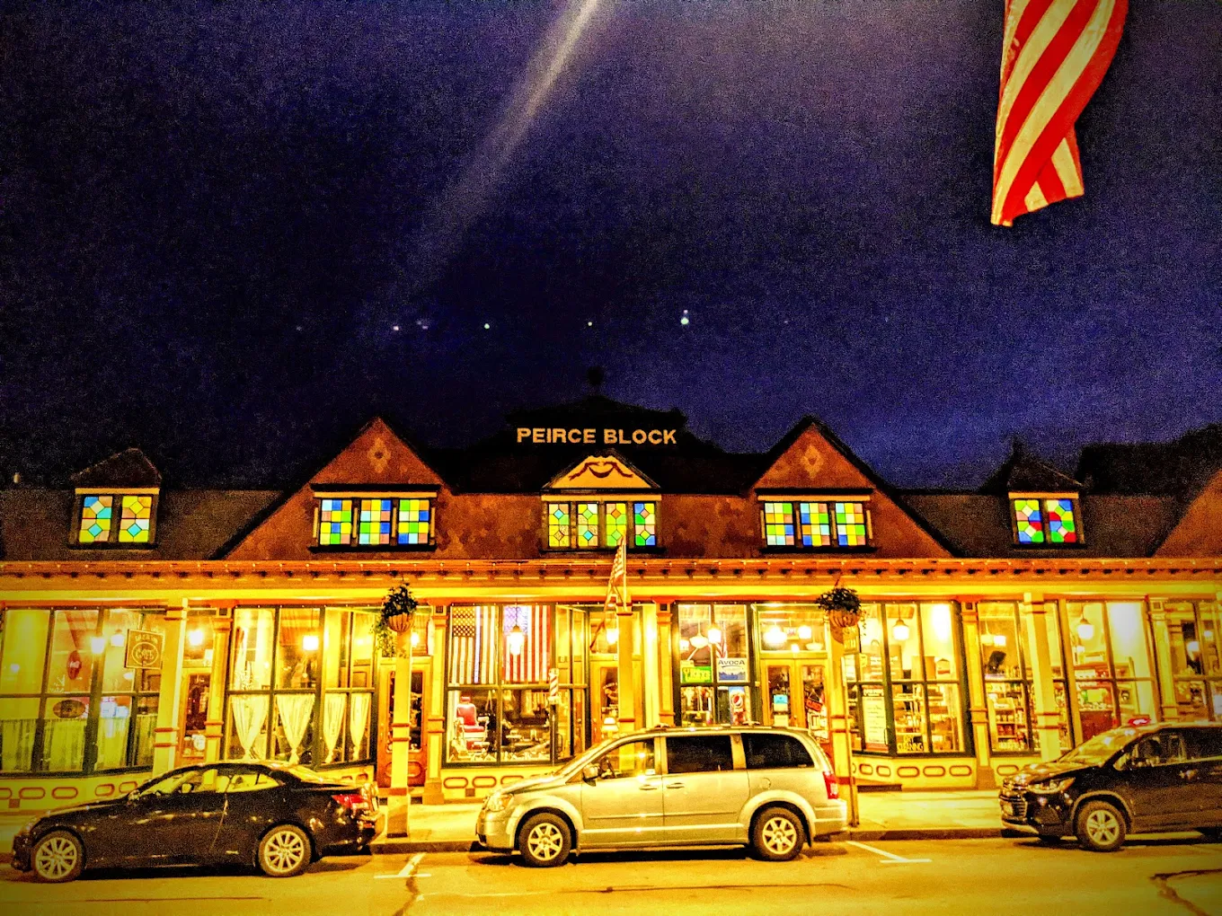 The Peirce Block at night with its stained glass windows lit from inside