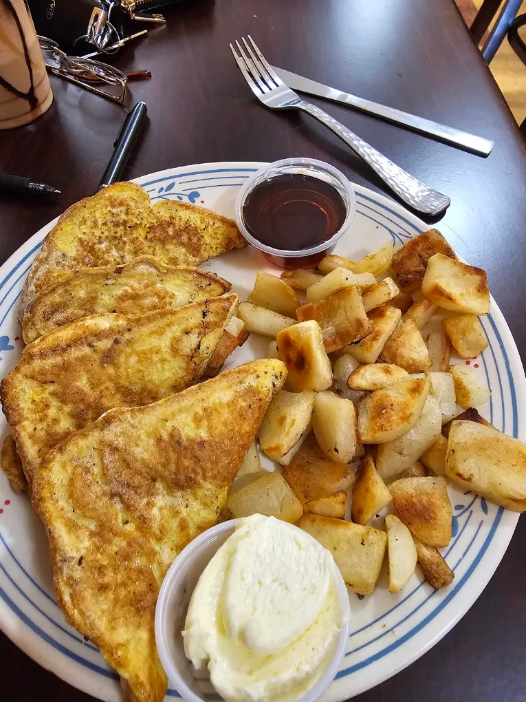 French toast with syrup, butter and home fries